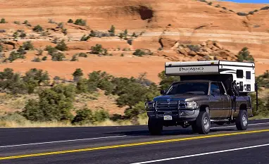 truck camper being driven on the road