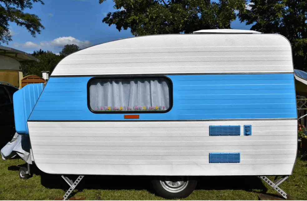 a small travel trailer parked outside a house