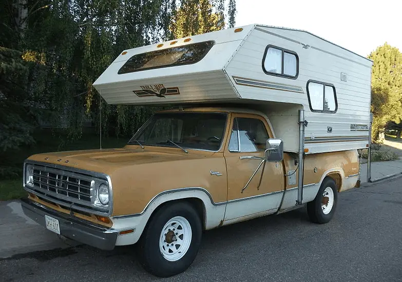 a truck camper parked on the side of the road